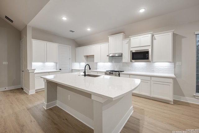 kitchen with white cabinets, built in microwave, and sink