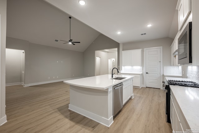 kitchen with tasteful backsplash, a kitchen island with sink, sink, and stainless steel appliances