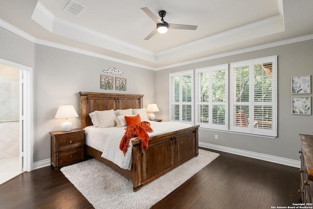 bedroom featuring connected bathroom, dark hardwood / wood-style floors, a raised ceiling, and ceiling fan