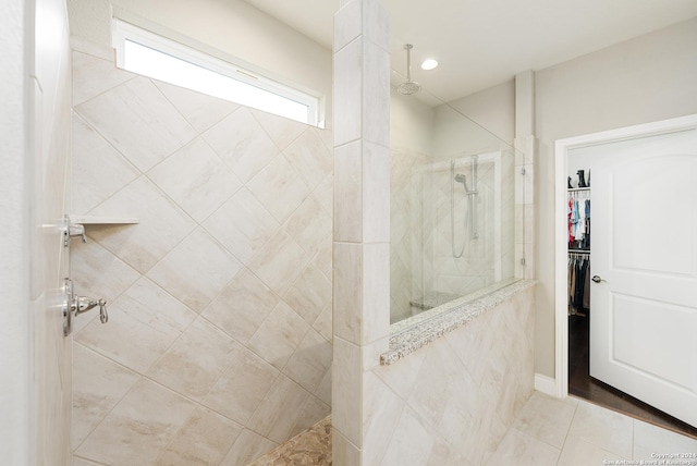 bathroom with tile patterned floors and tiled shower