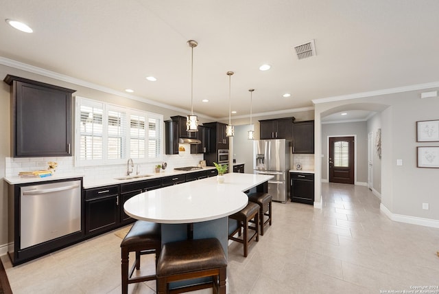 kitchen with decorative backsplash, a healthy amount of sunlight, a kitchen island, and stainless steel appliances