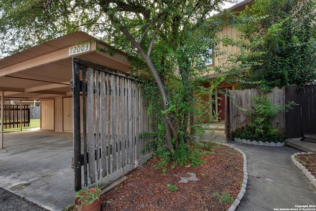 exterior space with a carport and fence