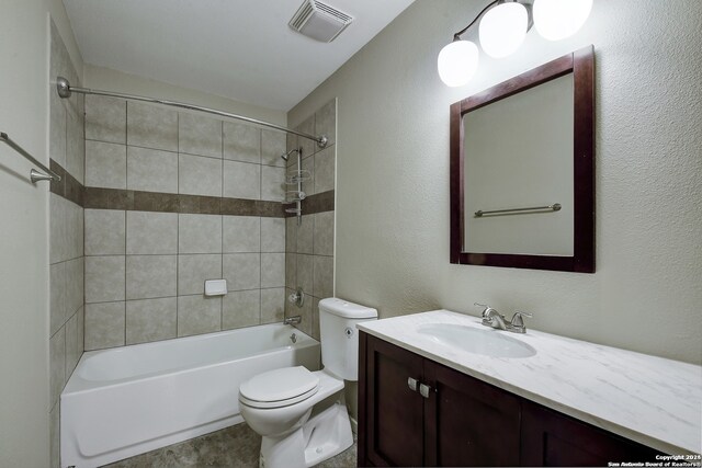 full bathroom with tiled shower / bath, toilet, and vanity