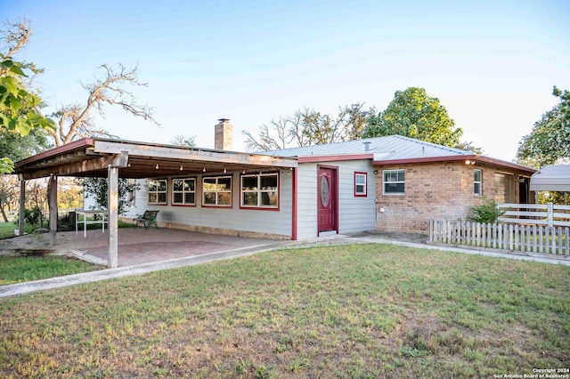 rear view of house featuring a yard and a patio