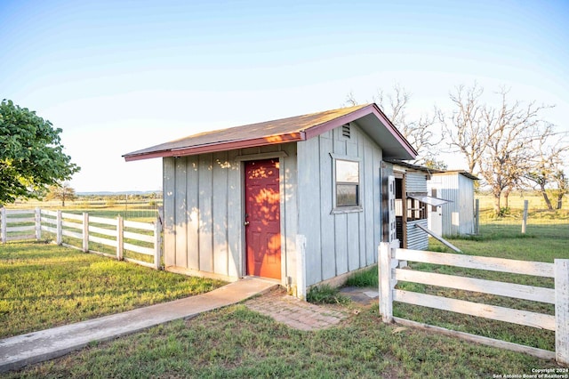 view of outdoor structure with a yard and a rural view