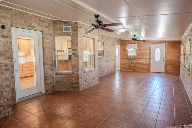 foyer entrance with brick wall and tile patterned flooring