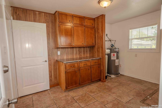 kitchen with water heater and wood walls