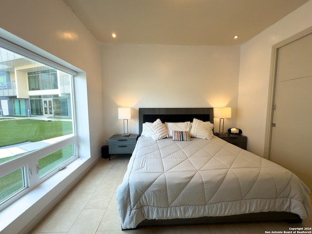 bedroom with light tile patterned floors and multiple windows