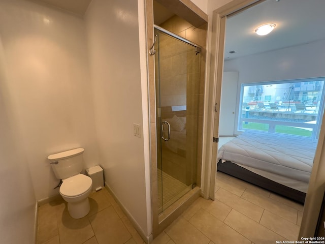 bathroom with tile patterned flooring, a shower with door, and toilet