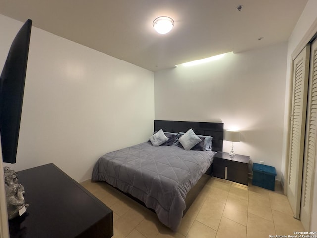 tiled bedroom with a closet