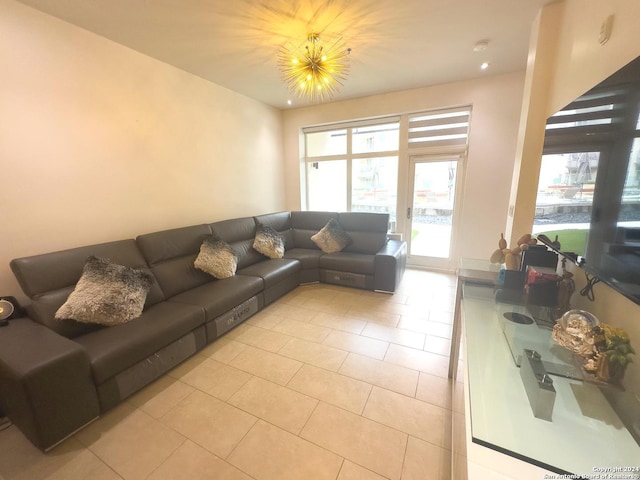 living room with light tile patterned floors and an inviting chandelier