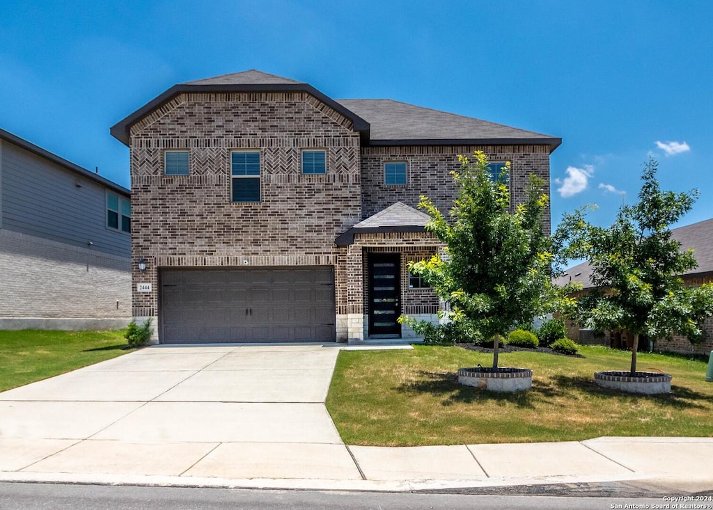 view of front of home with a garage and a front lawn