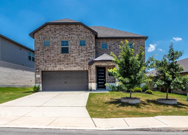 view of front of home with a garage and a front lawn