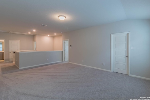 empty room with light carpet and lofted ceiling