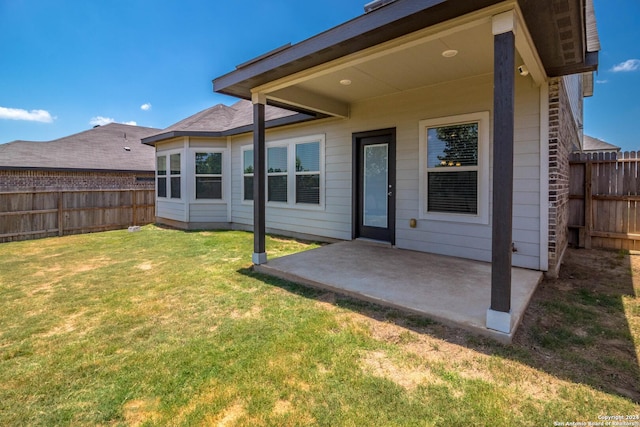 back of house with a yard and a patio