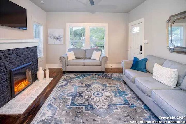 living room featuring dark wood-type flooring and ceiling fan