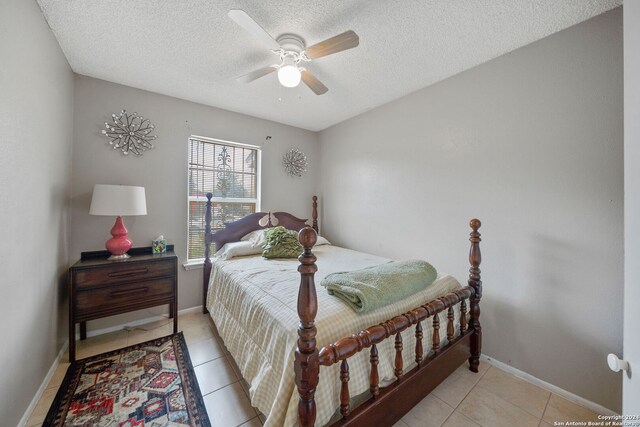 bedroom with light tile patterned floors, a textured ceiling, and ceiling fan