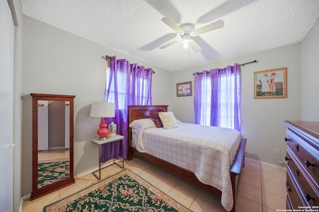 tiled bedroom featuring ceiling fan and a textured ceiling