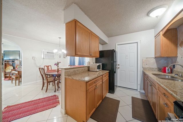 kitchen featuring sink, backsplash, pendant lighting, a textured ceiling, and light tile patterned flooring