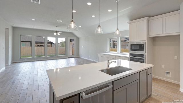 kitchen featuring hanging light fixtures, sink, light hardwood / wood-style flooring, appliances with stainless steel finishes, and white cabinetry