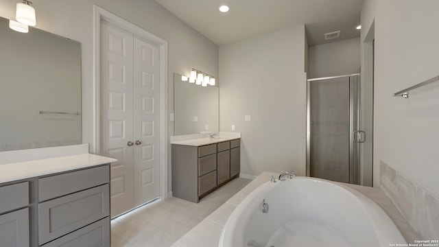 bathroom featuring plus walk in shower, vanity, and tile patterned floors