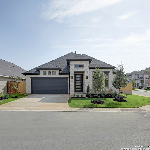 view of front of home featuring a front yard and a garage