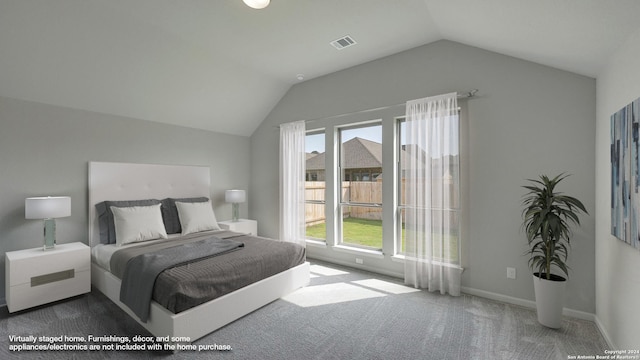 carpeted bedroom with vaulted ceiling and multiple windows