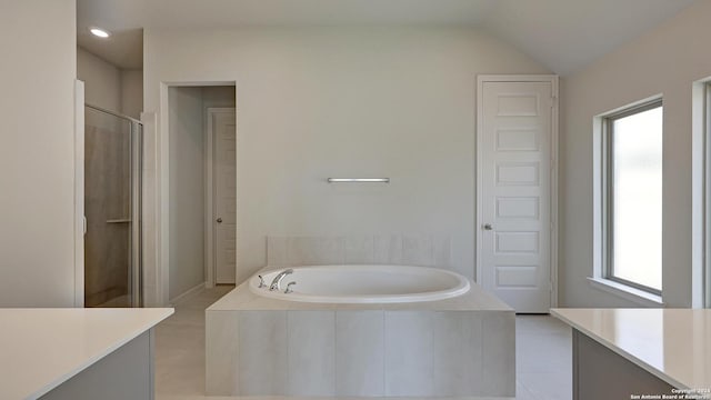 bathroom featuring tile patterned floors, vanity, vaulted ceiling, and independent shower and bath