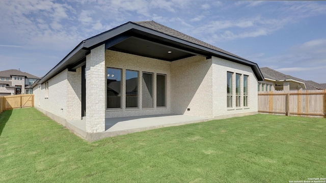 back of house featuring a lawn and a patio area