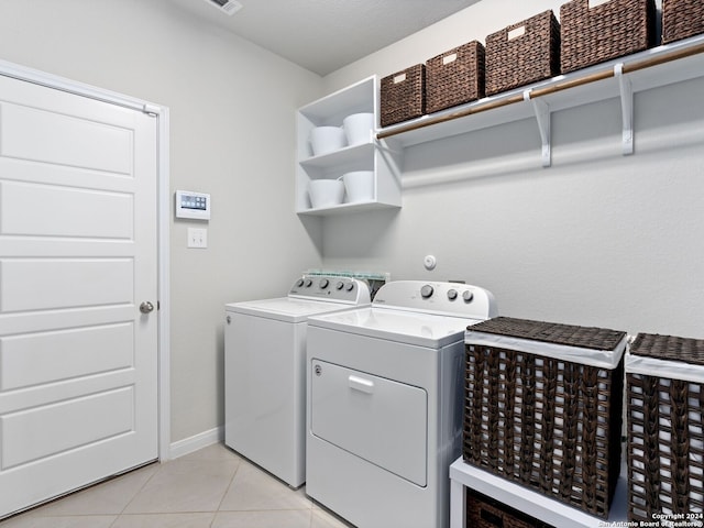 laundry area with light tile flooring and washing machine and dryer