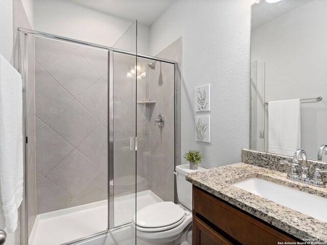 bathroom with walk in shower, toilet, and large vanity