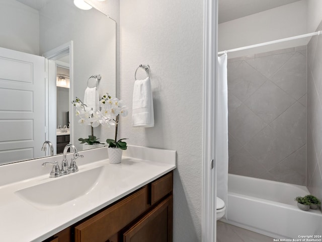 full bathroom with tile floors, vanity with extensive cabinet space, shower / bath combo with shower curtain, and toilet