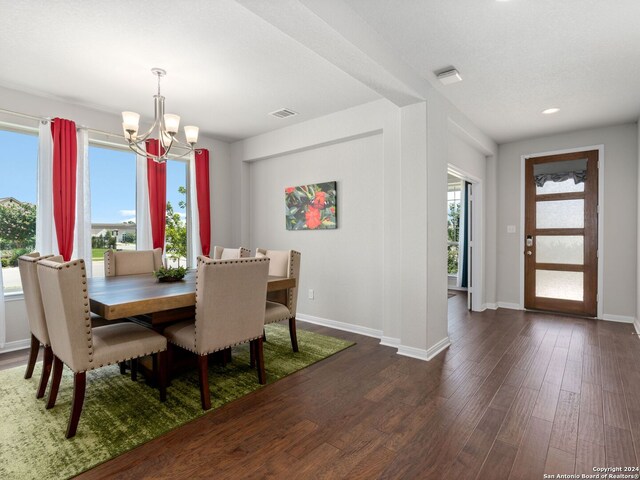 dining area with an inviting chandelier, plenty of natural light, and dark hardwood / wood-style floors