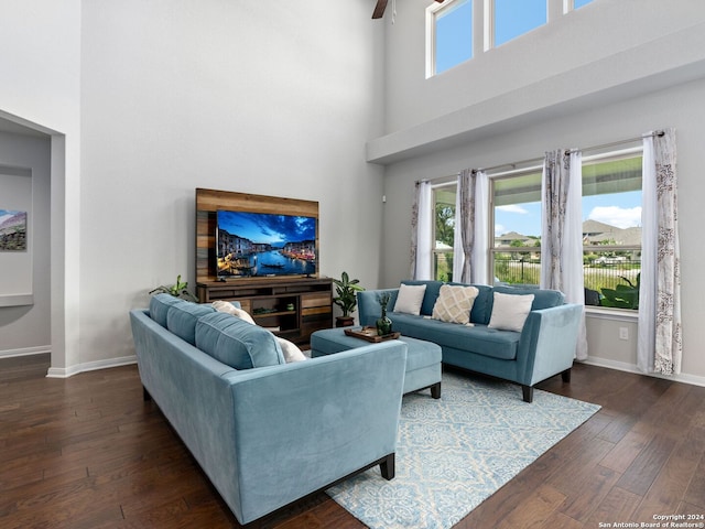 living room featuring dark hardwood / wood-style flooring, a high ceiling, and plenty of natural light