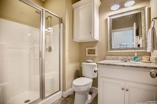 bathroom featuring tile patterned flooring, vanity, toilet, and walk in shower