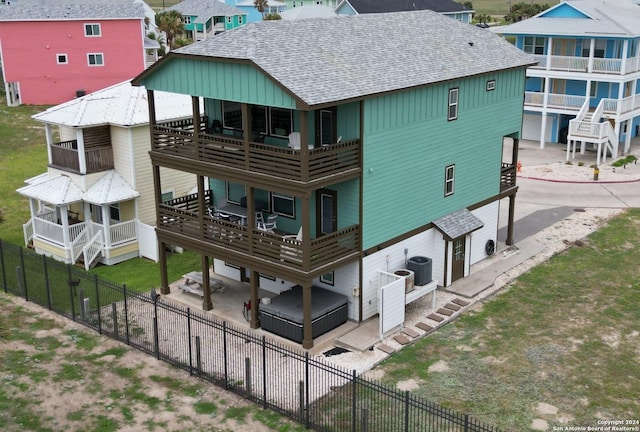 rear view of property with cooling unit and a balcony