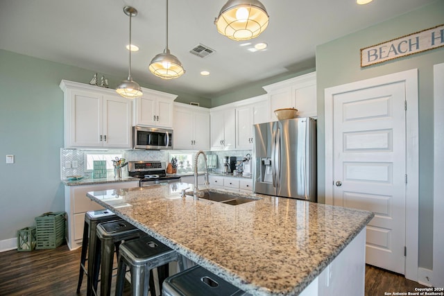 kitchen featuring sink, stainless steel appliances, an island with sink, and white cabinets