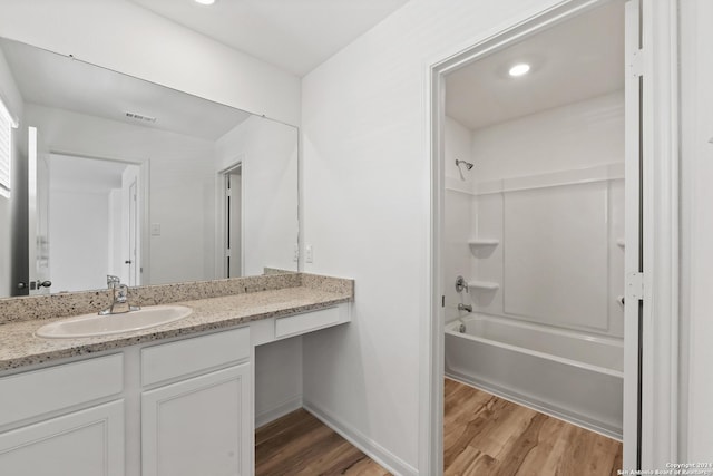 bathroom featuring hardwood / wood-style flooring, vanity, and shower / bath combination