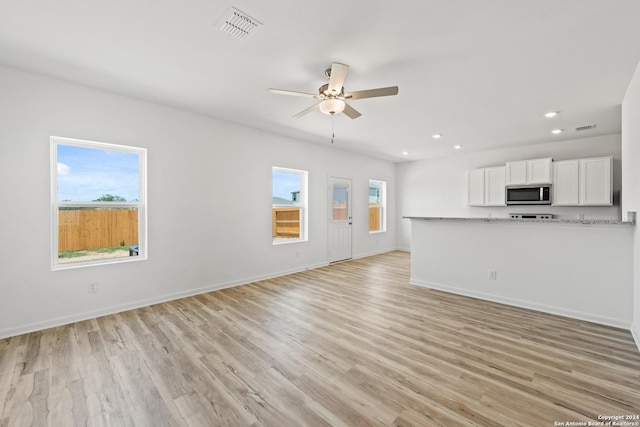 unfurnished living room with ceiling fan, a healthy amount of sunlight, and light hardwood / wood-style floors