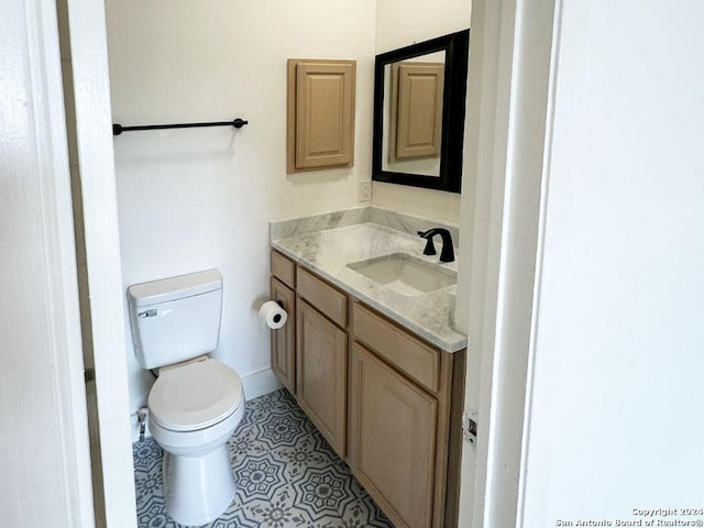 bathroom with toilet, tile patterned floors, and vanity