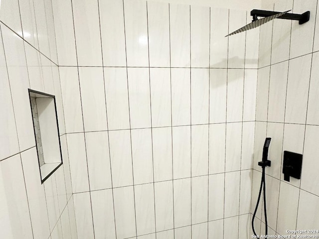 interior details featuring a tile shower