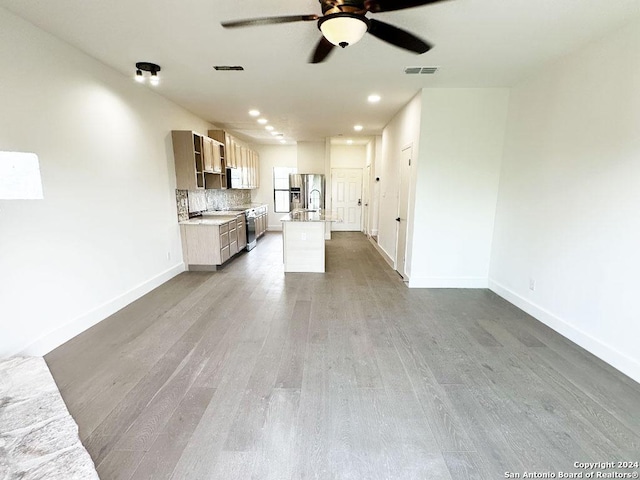 unfurnished living room featuring hardwood / wood-style floors and ceiling fan