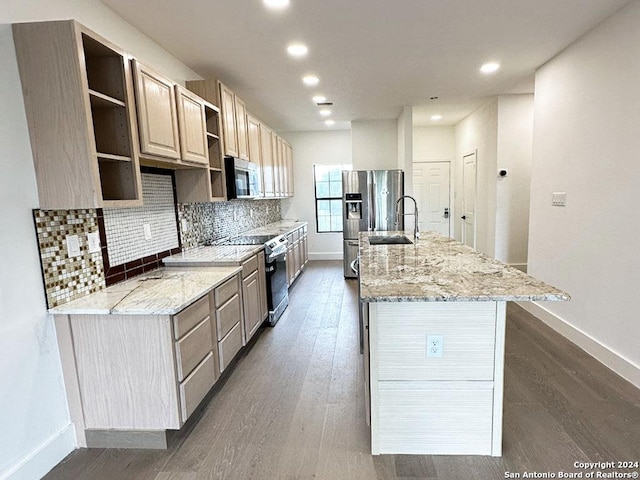 kitchen featuring stainless steel appliances, sink, an island with sink, light stone countertops, and dark wood-type flooring