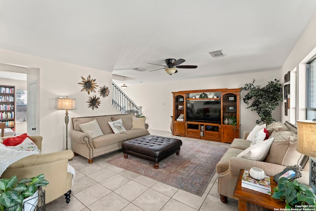 tiled living room with a wealth of natural light and ceiling fan