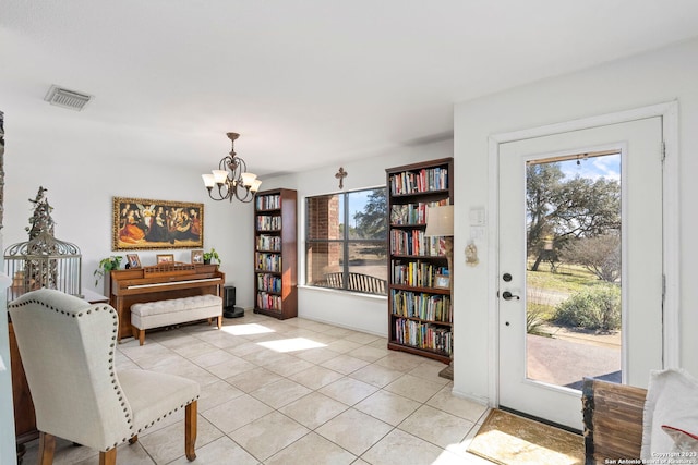 living area with an inviting chandelier and light tile flooring