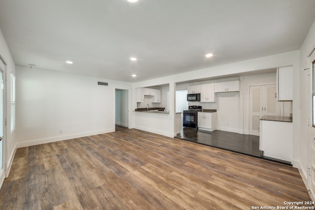 unfurnished living room featuring sink and hardwood / wood-style flooring