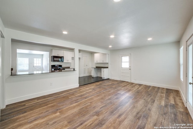 unfurnished living room with dark wood-type flooring