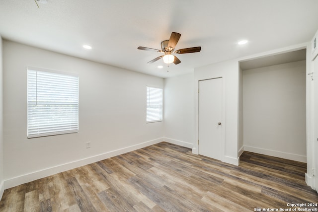 unfurnished bedroom featuring hardwood / wood-style floors, a closet, and ceiling fan