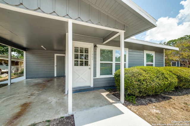 view of exterior entry with a carport