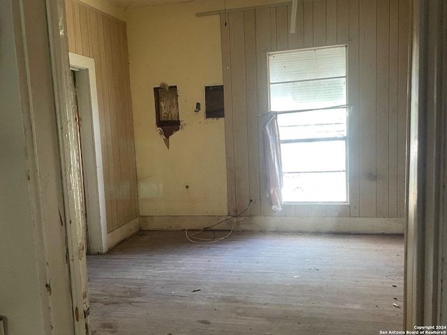 spare room featuring wooden walls and light wood-style flooring